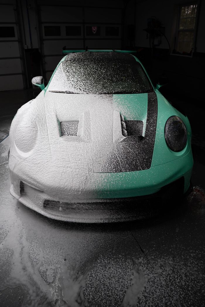 Green Porsche covered in white foam
