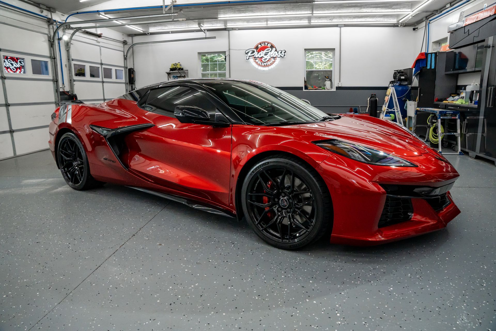 Red Chevrolet Camaro convertible in a garage with a gray epoxy floor.