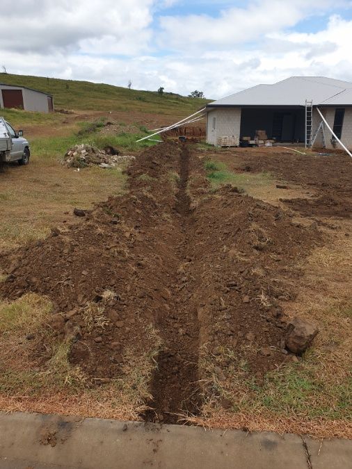 A Car Is Parked In A Dirt Field In Front Of A House — Rockyview Excavations In Rockyview, QLD