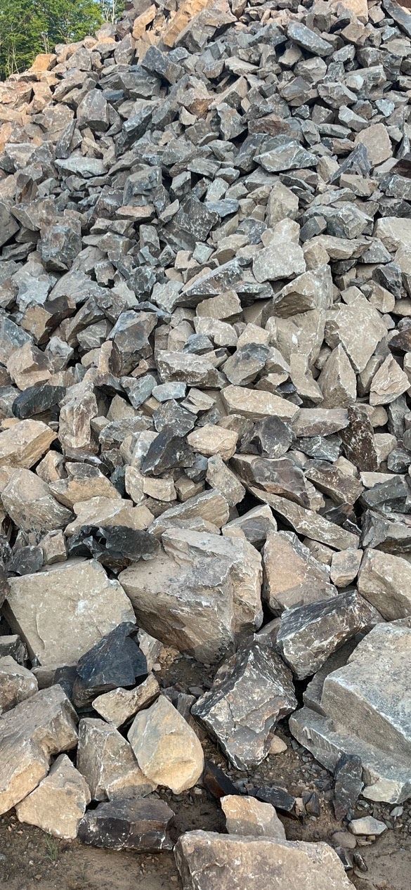 A pile of rocks sitting on top of each other on the ground.