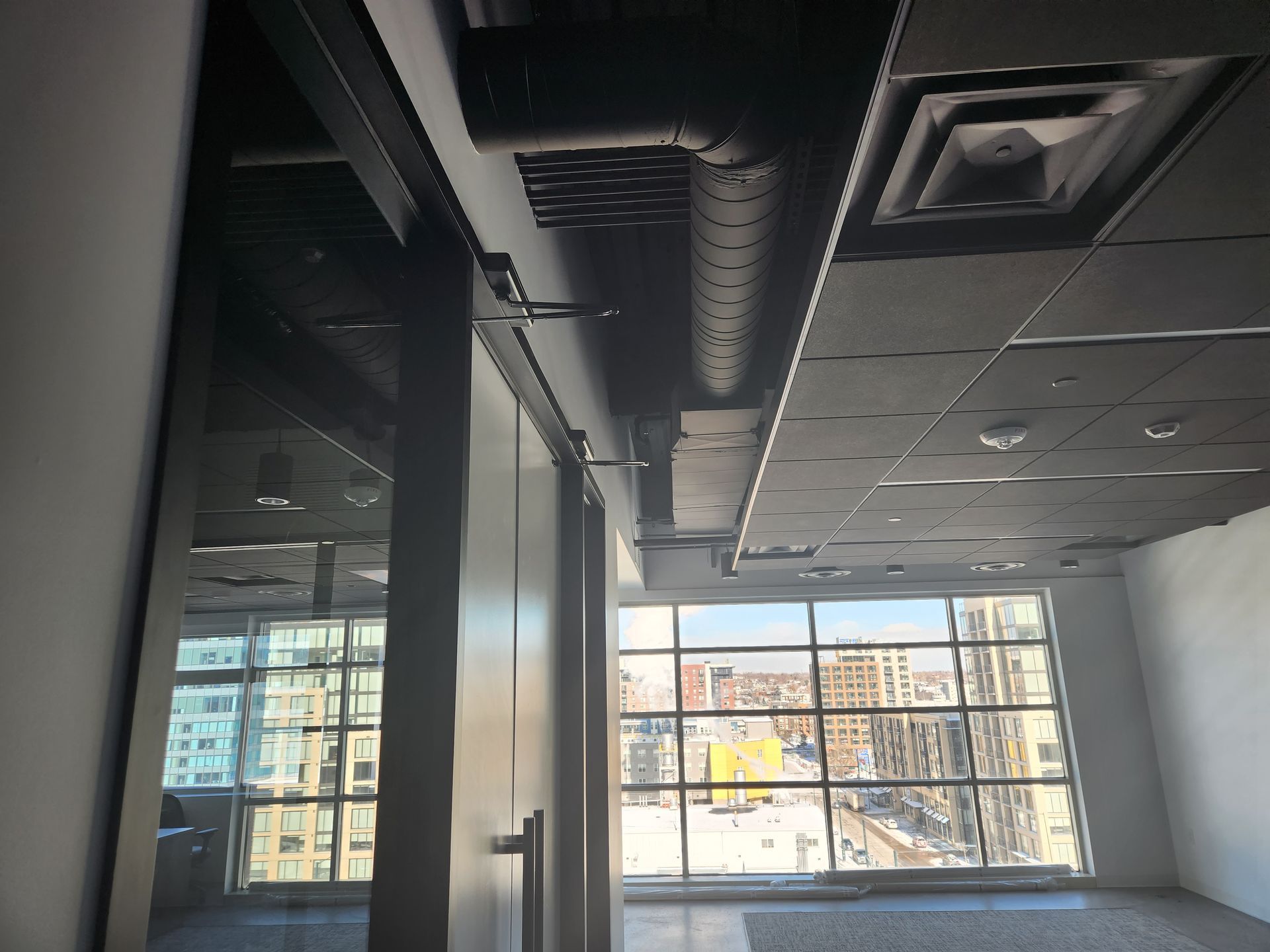 HVAC technicians installing ductwork and outdoor units in a commercial building.