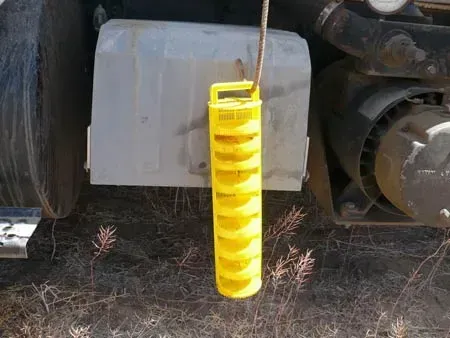 A yellow object is hanging from the side of a truck.