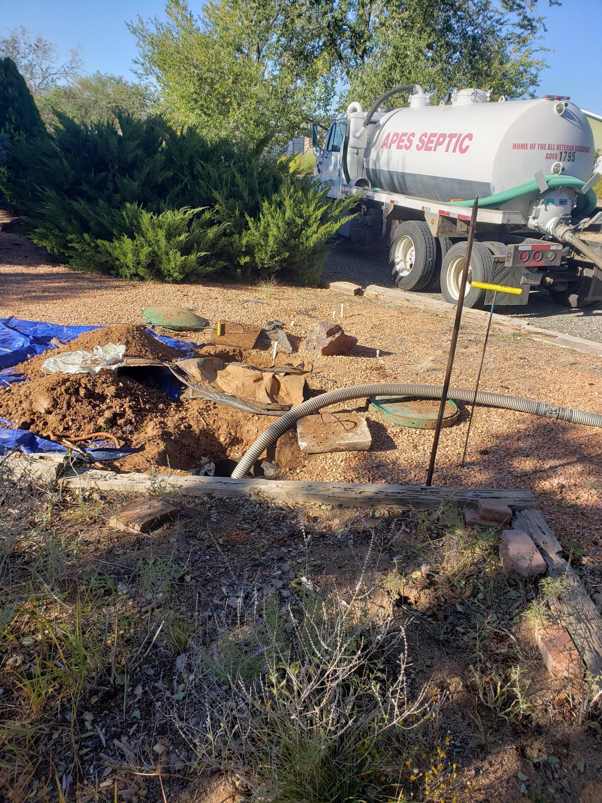 A septic tank is being pumped into a hole in the ground.