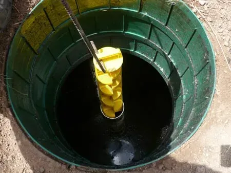 A green barrel filled with water and a yellow object in it.