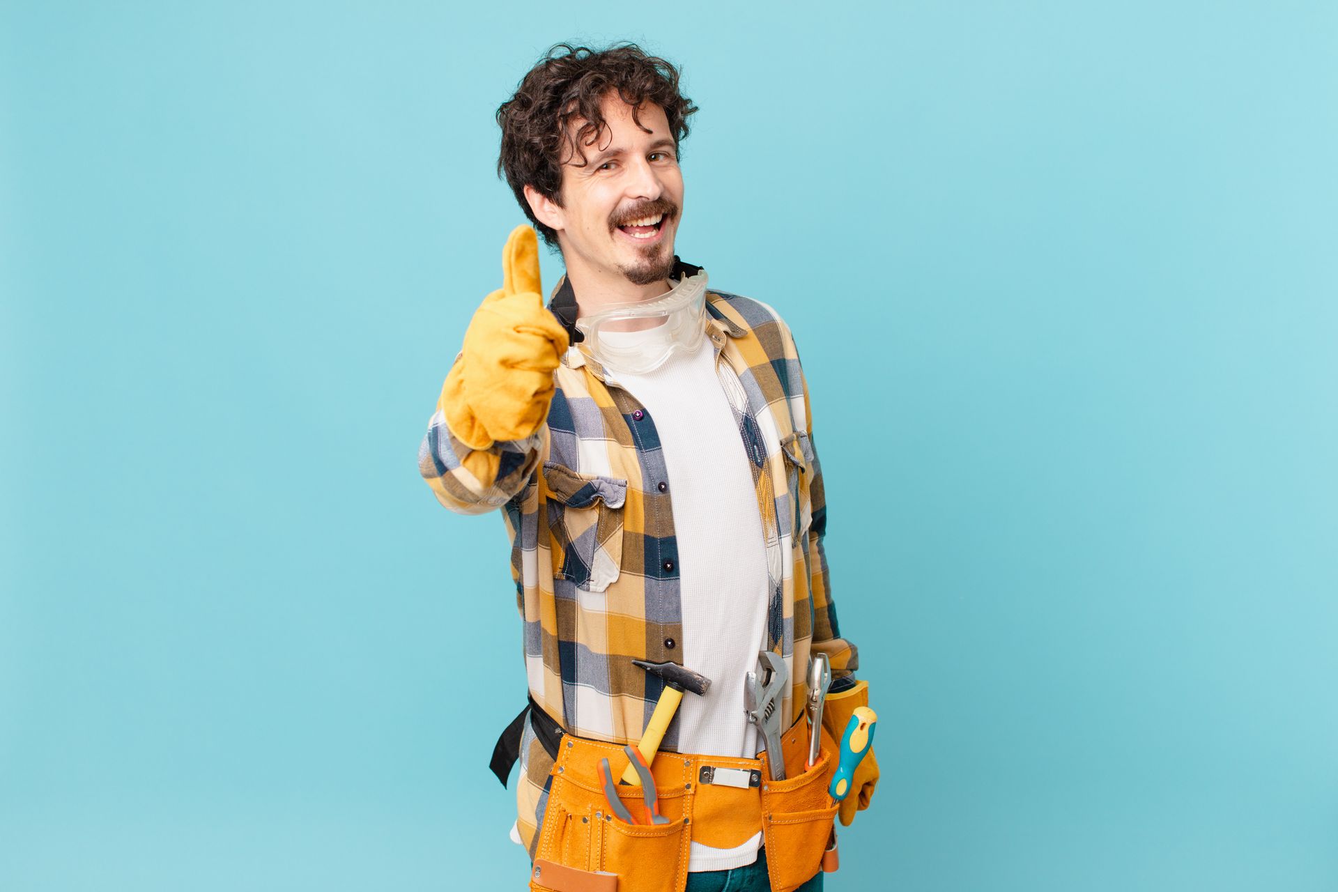 A man wearing a tool belt and gloves is giving a thumbs up.