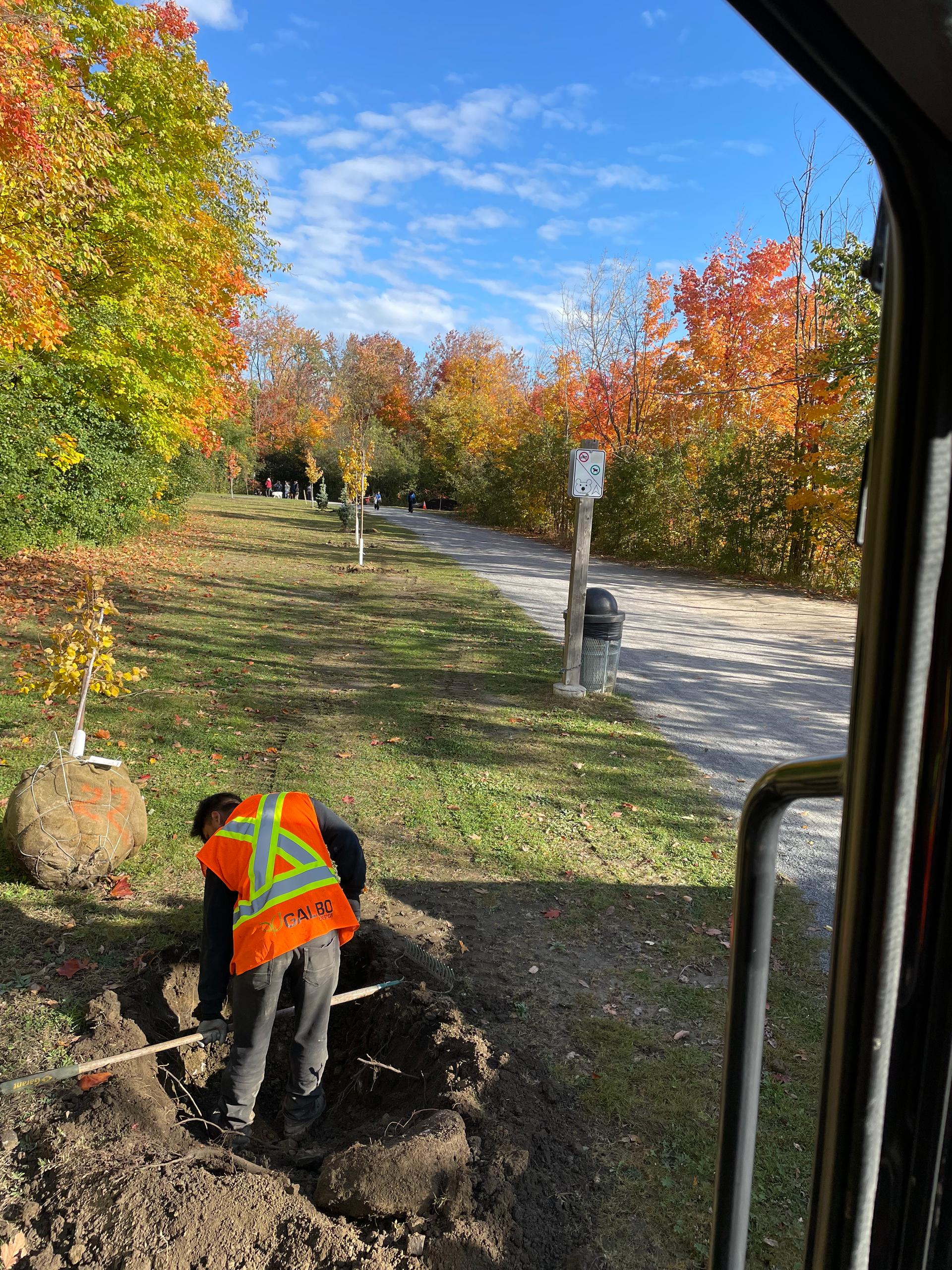 Un homme vêtu d'un gilet orange creuse dans la terre.