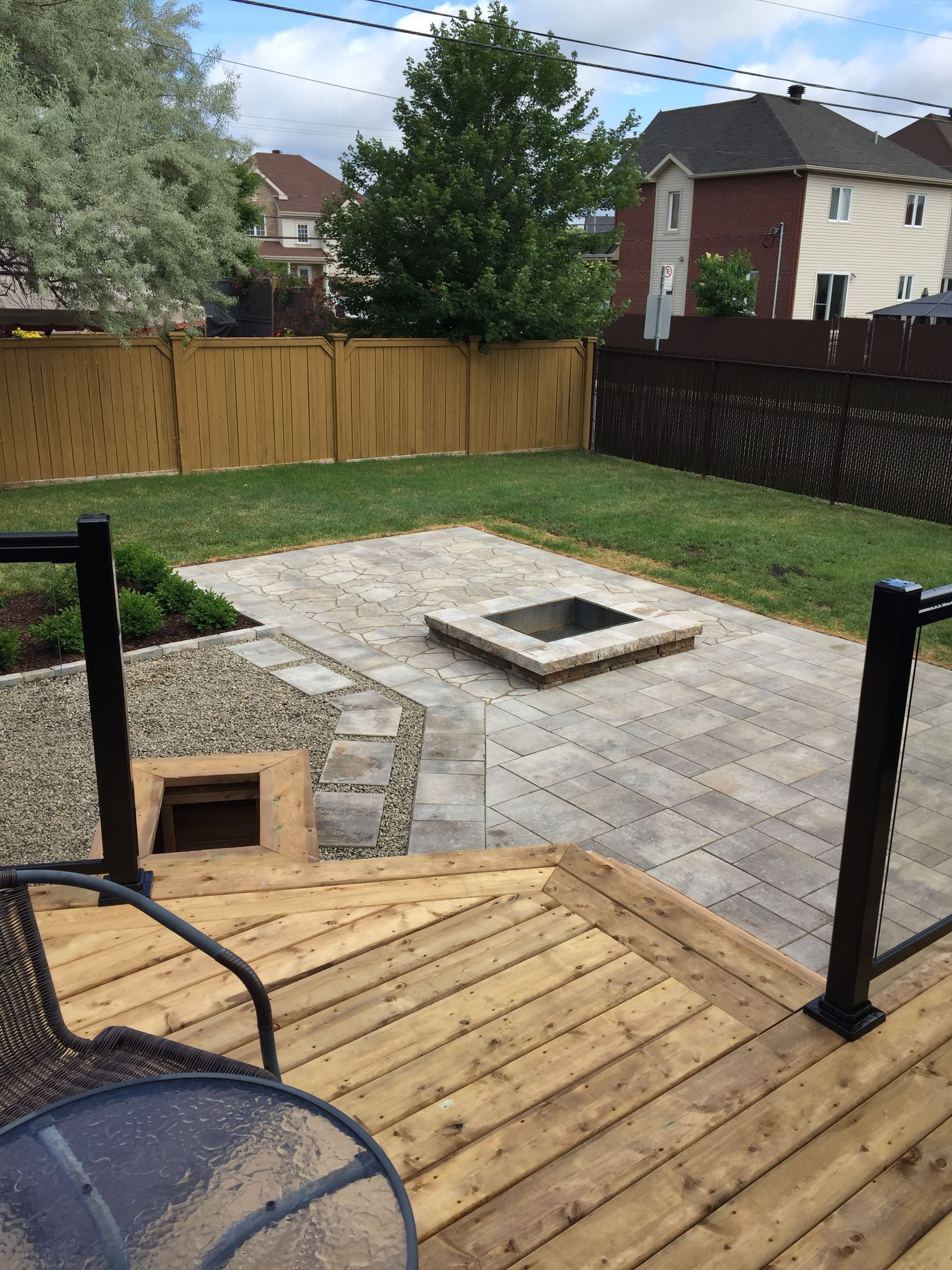 Une terrasse en bois avec un foyer dans la cour