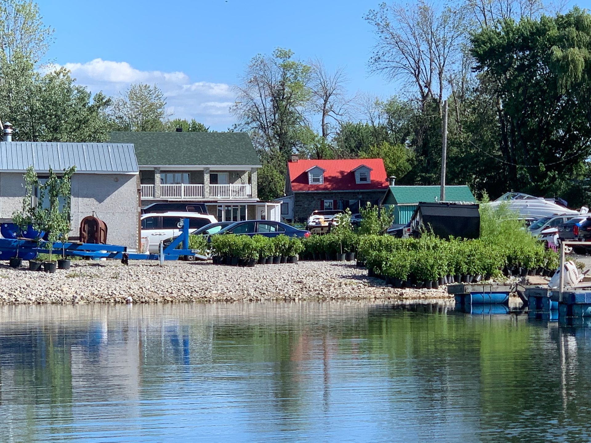 Une maison au toit rouge se trouve à côté d’un plan d’eau
