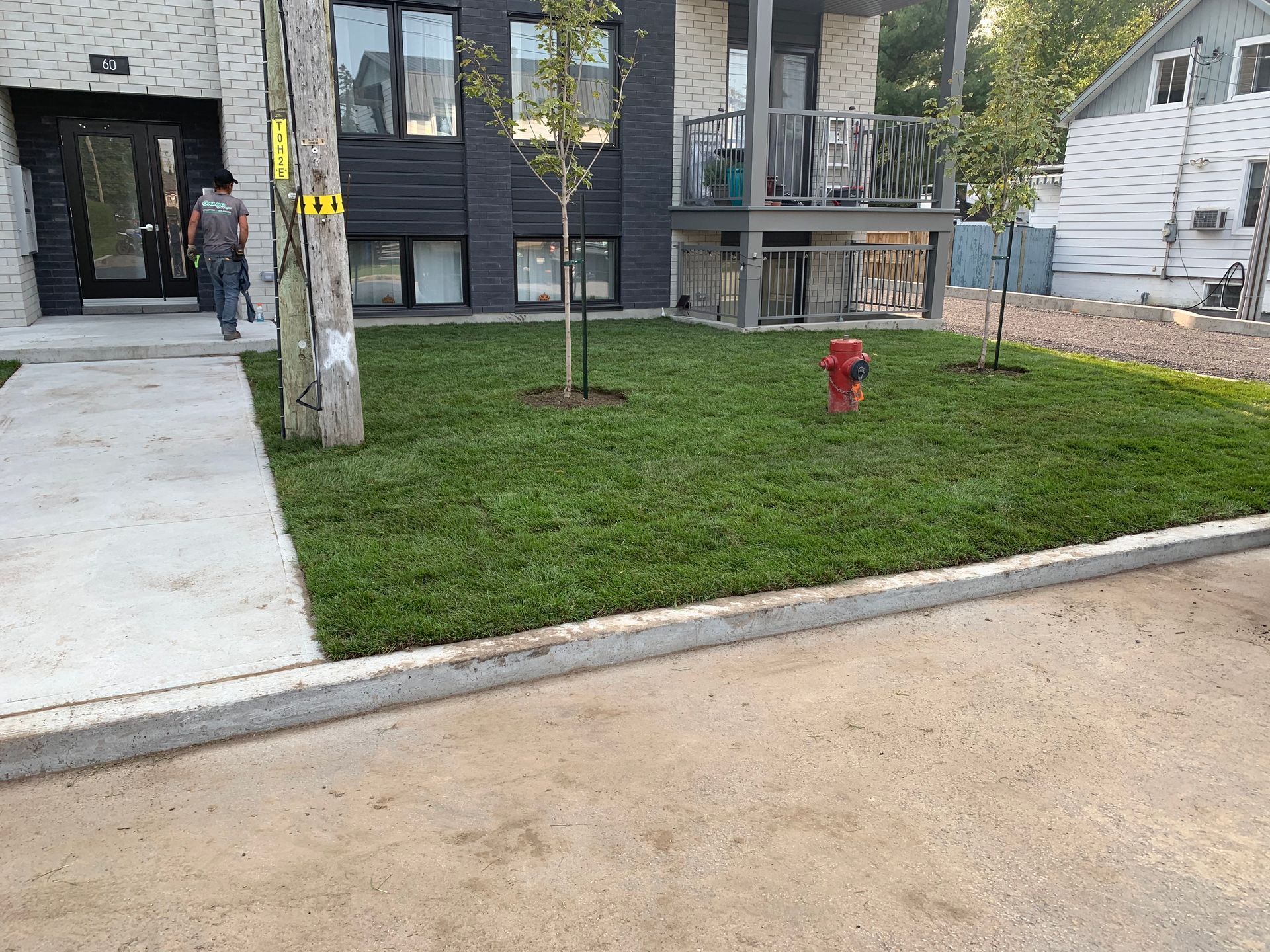 Une bouche d'incendie se trouve au milieu d'une pelouse verdoyante devant un bâtiment.