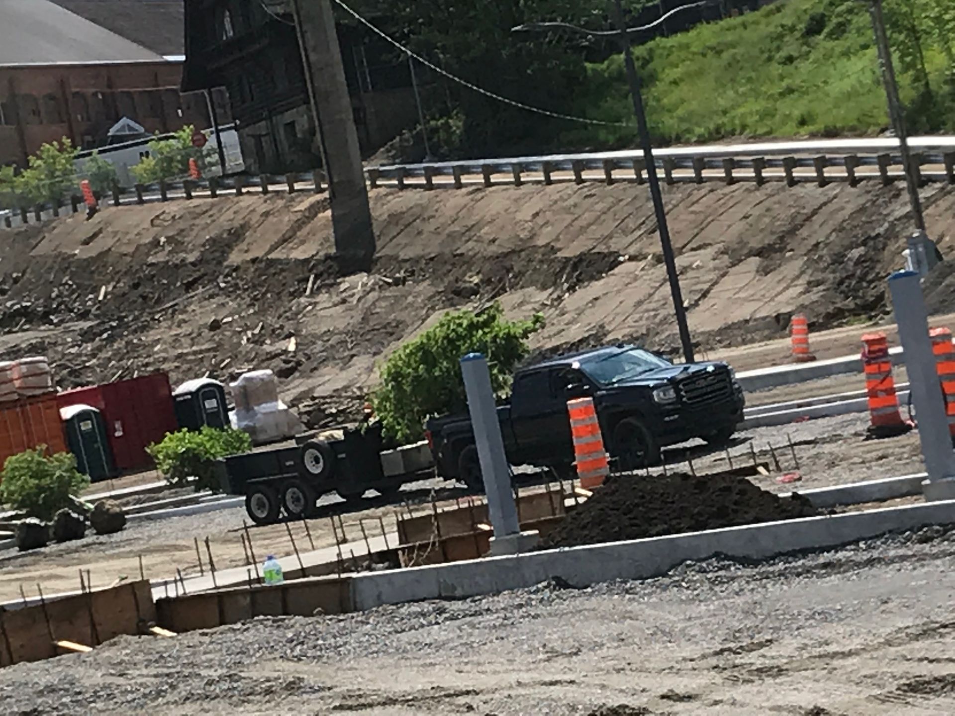 Un camion roule sur une route à côté d'un chantier de construction.