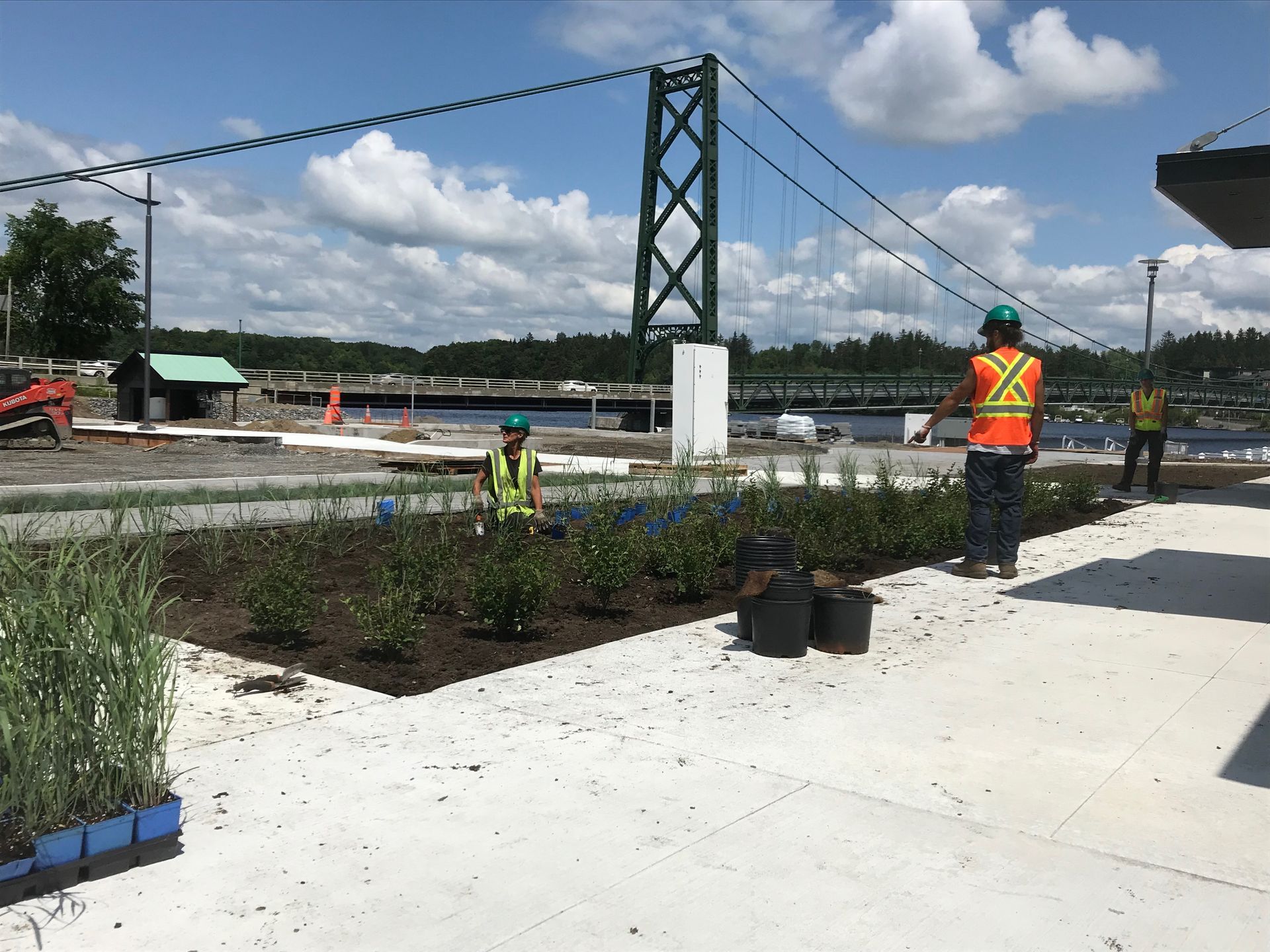 Un groupe d'ouvriers du bâtiment se tient devant un pont.
