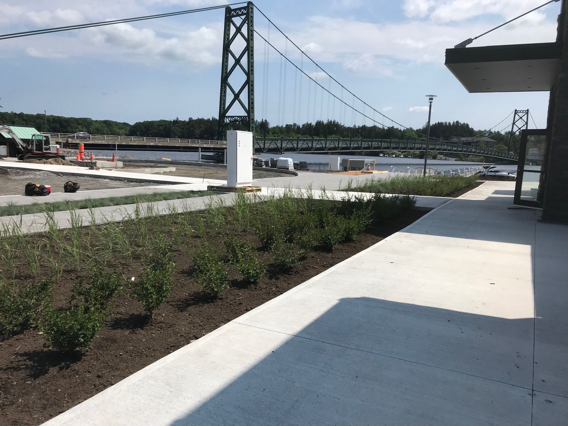 Une passerelle en béton menant à un pont au-dessus d'un plan d'eau