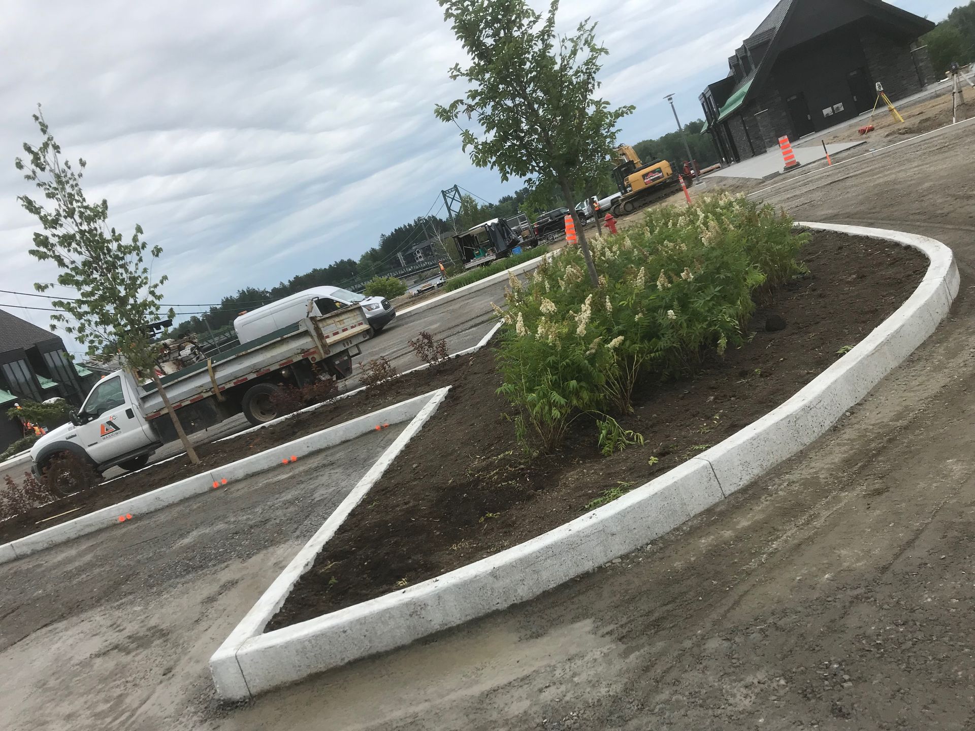 Un camion blanc est garé dans un parking à côté d'un trottoir incurvé.