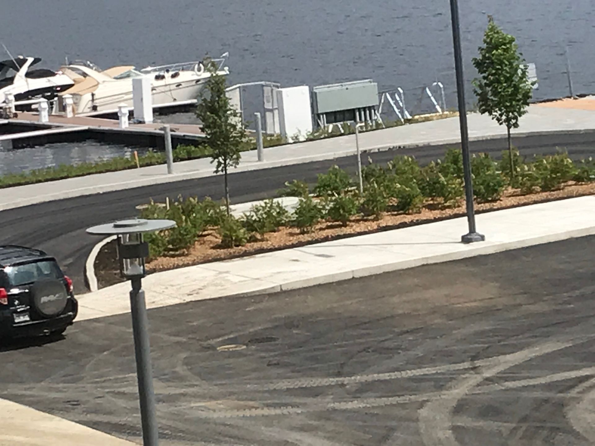 Un suv noir est garé dans un parking à côté d'un plan d'eau