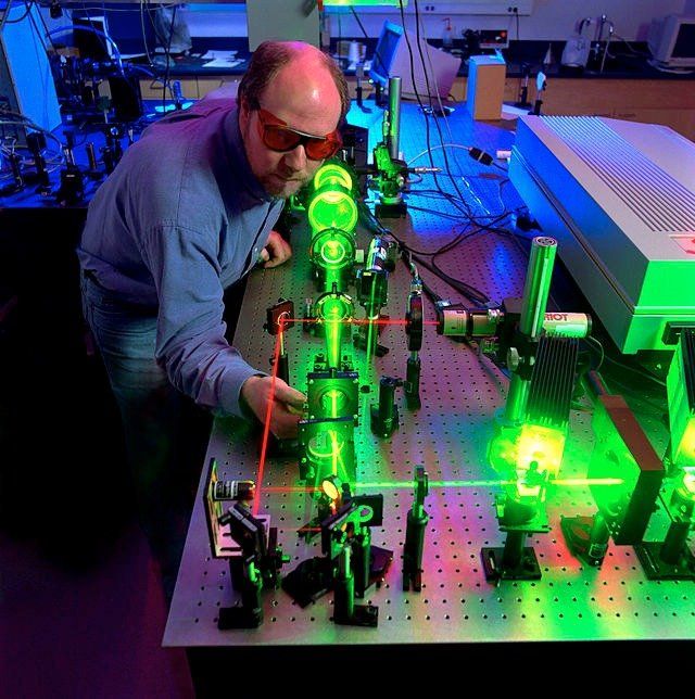 man adjusting a laser in a lab
