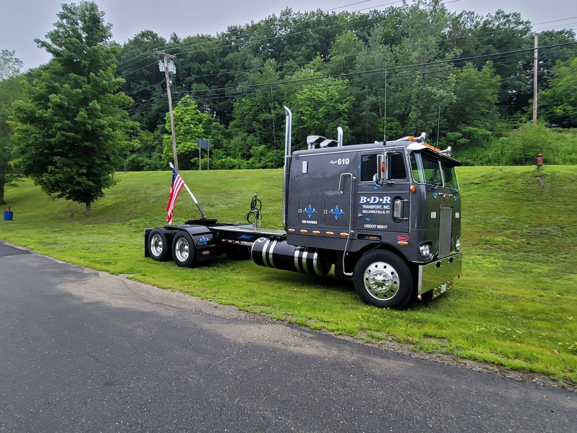 A black semi truck is parked on the side of the road