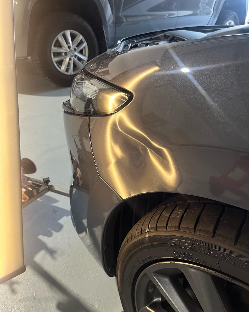 A Car with A Damaged Bumper Is Parked in A Garage — Dent Motive in Nerang, QLD