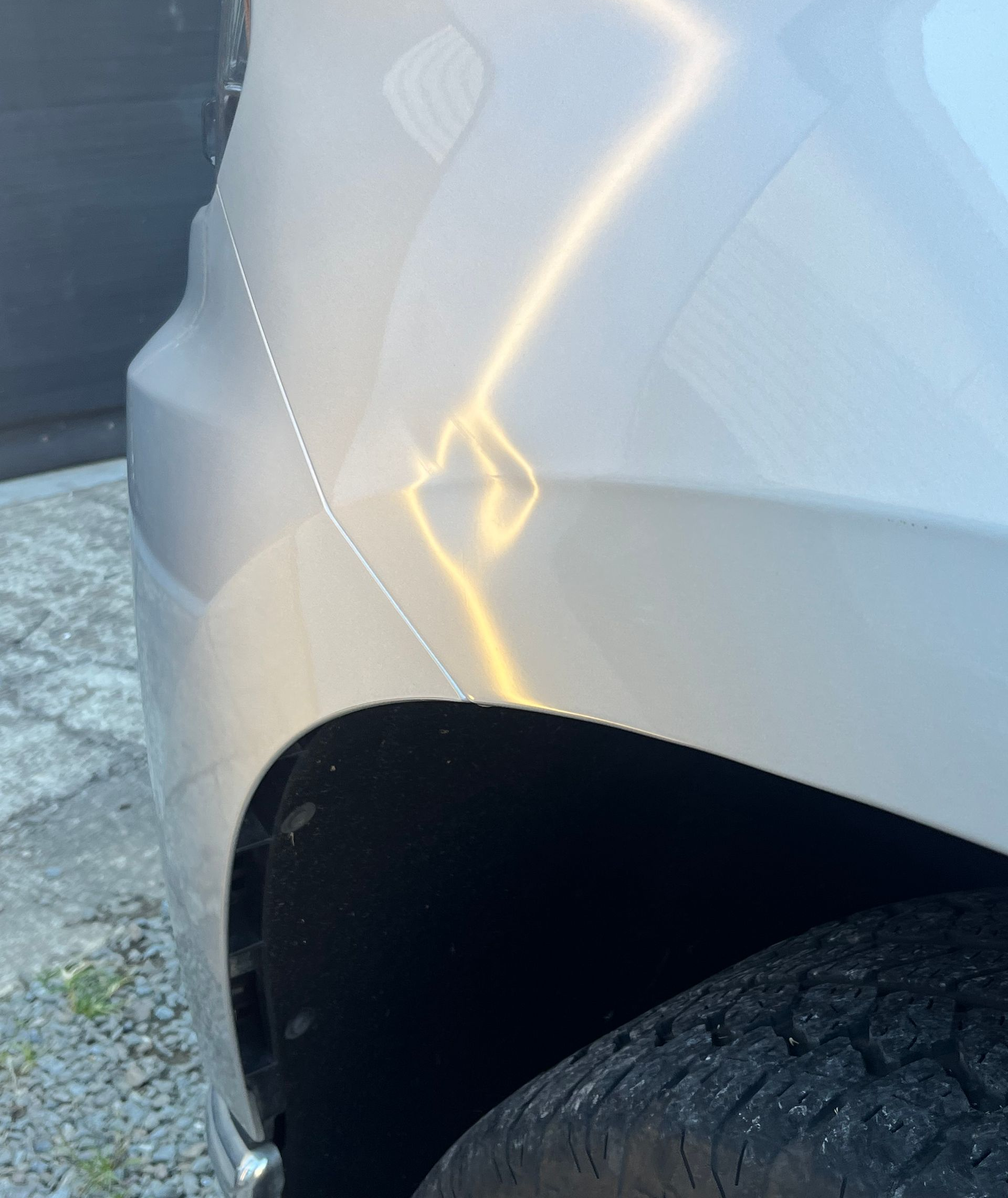 Silver car fender with dent above the wheel — Dent Motive in Nerang, QLD