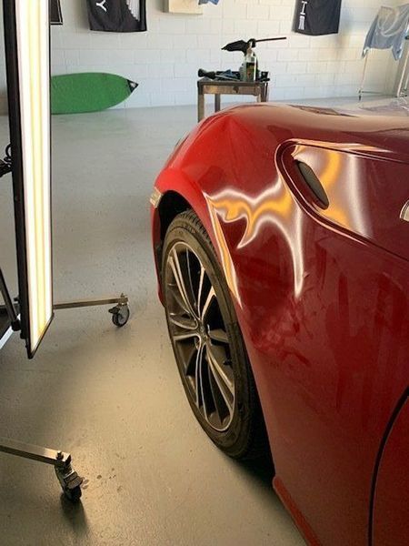 A Red Sports Car Is Parked in A Garage — Dent Motive in Nerang, QLD