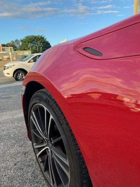 A Red Car Is Parked on The Side of The Road — Dent Motive in Nerang, QLD
