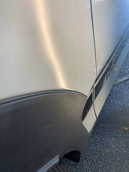 A White Car with A Black Stripe on The Side Is Parked on The Side of The Road — Dent Motive in Nerang, QLD