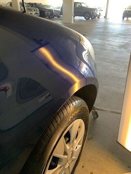 A Blue Car with A Dent in The Fender Is Parked in A Parking Garage — Dent Motive in Nerang, QLD