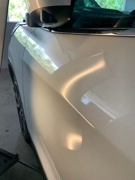 A White Car Is Parked in A Garage with The Hood Up — Dent Motive in Nerang, QLD