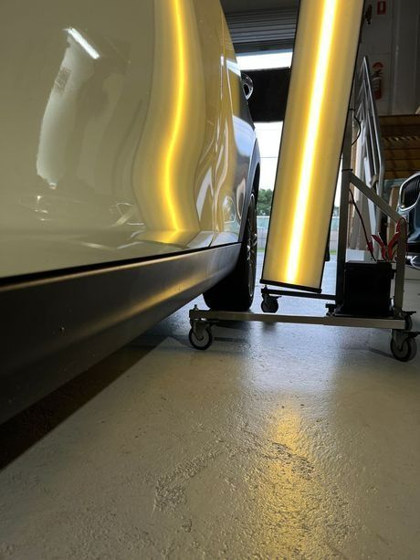 A White Car Is Being Worked on in a Garage — Dent Motive in Nerang, QLD