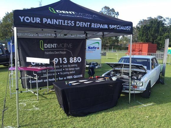 A Car Is Parked Under a Tent that Says Your Painless Dent Repair Specialist — Dent Motive in Nerang, QLD