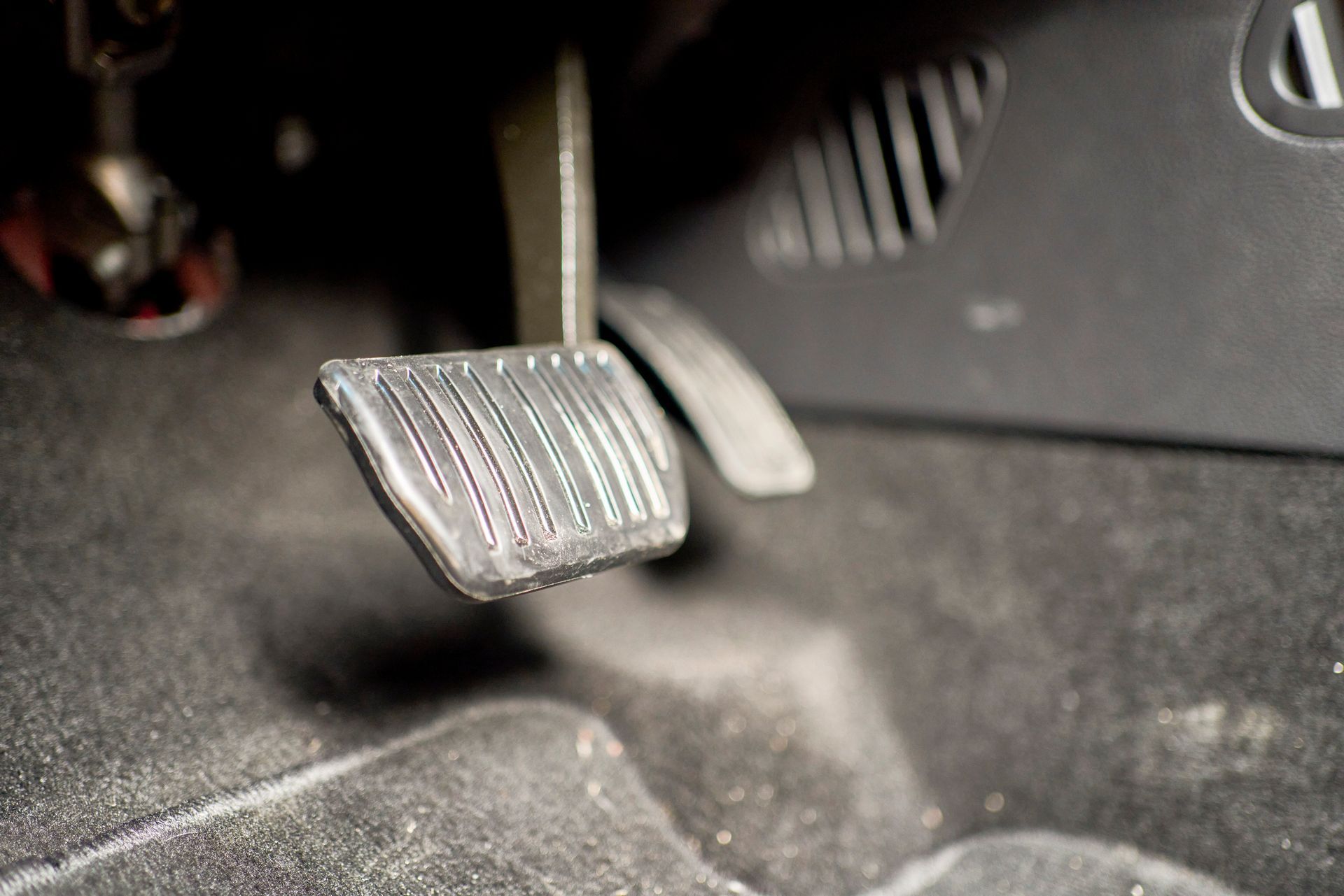 A close up of a brake pedal in a car.