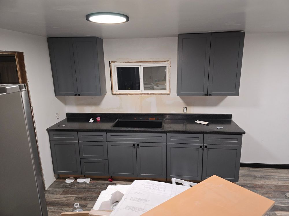 A large room with a lot of cabinets and a ceiling fan.