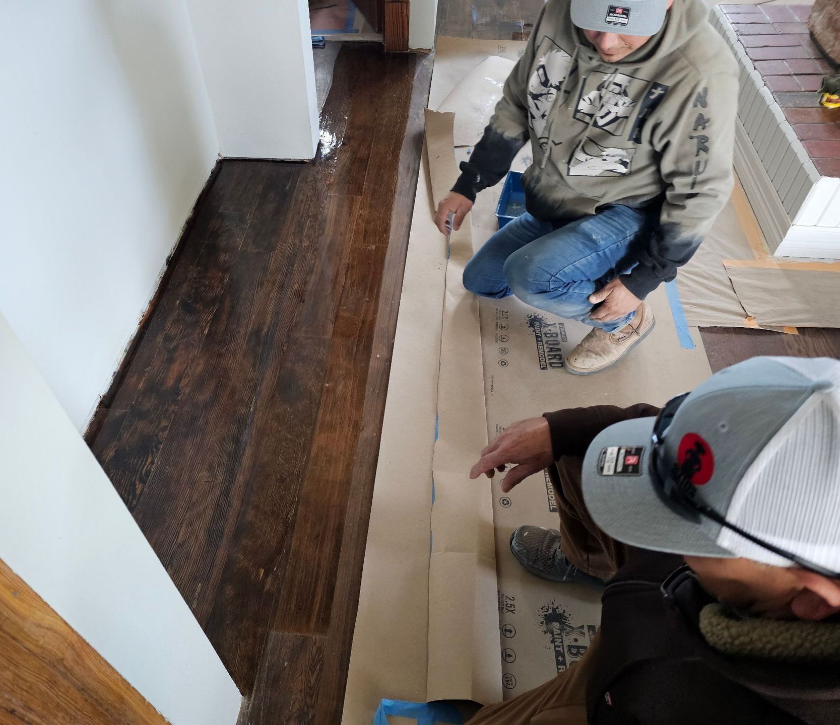 A person is measuring a piece of wood with a pencil.