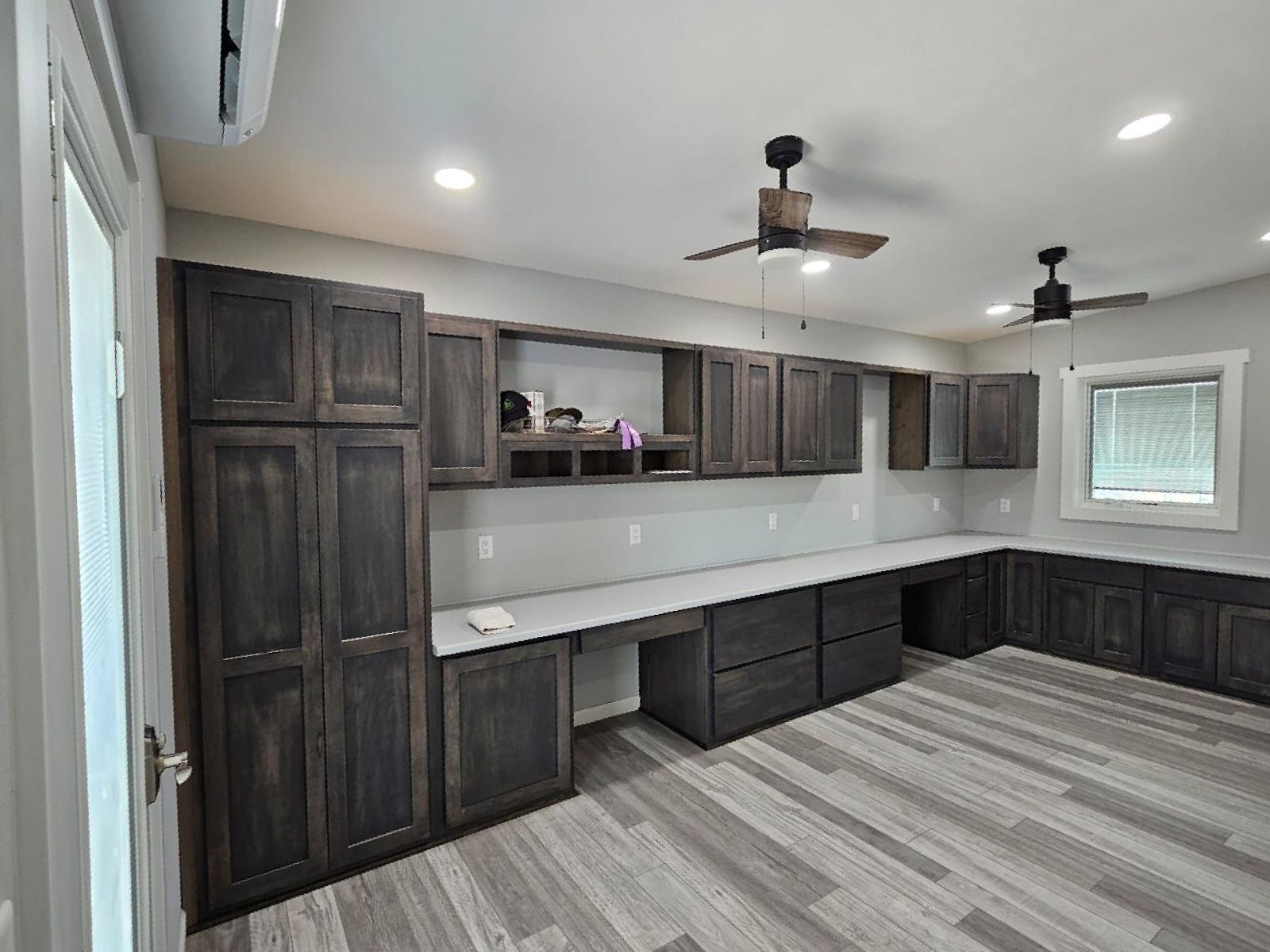 A room with a lot of cabinets and a ceiling fan.