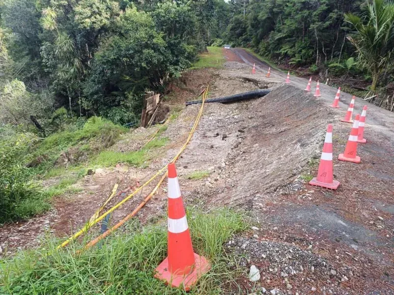 A row of orange and white traffic cones on the side of a road.