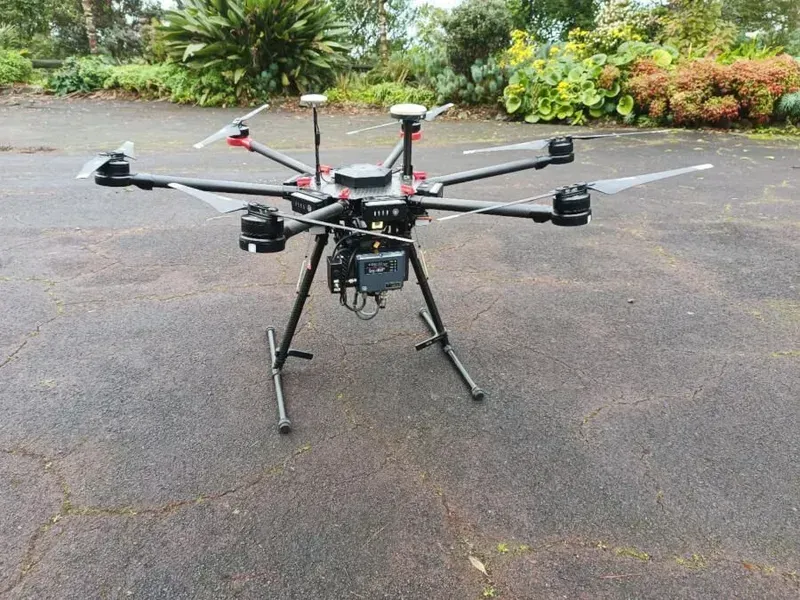 A drone is sitting on the ground in a parking lot.