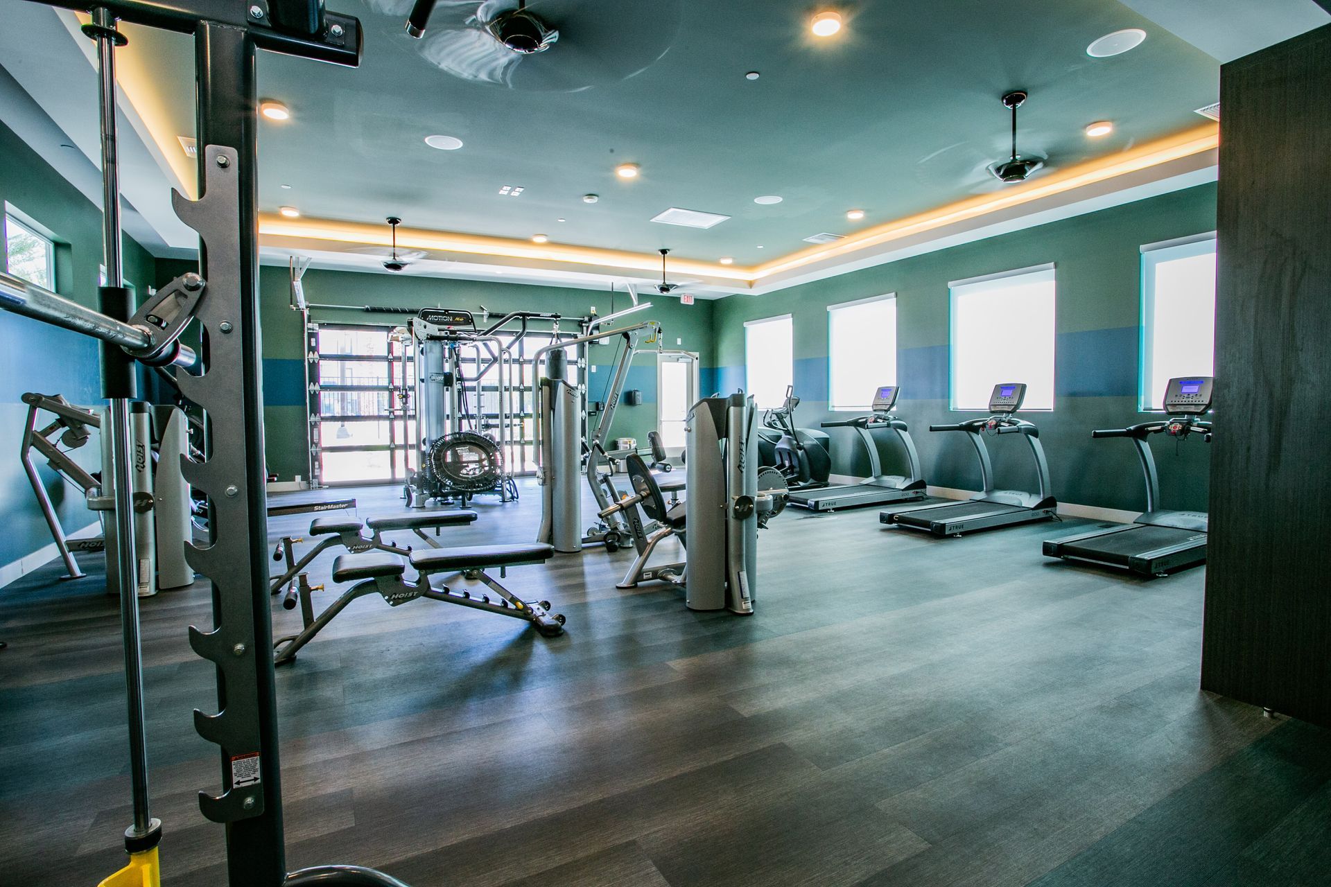 A large gym with a lot of equipment and a lot of windows.