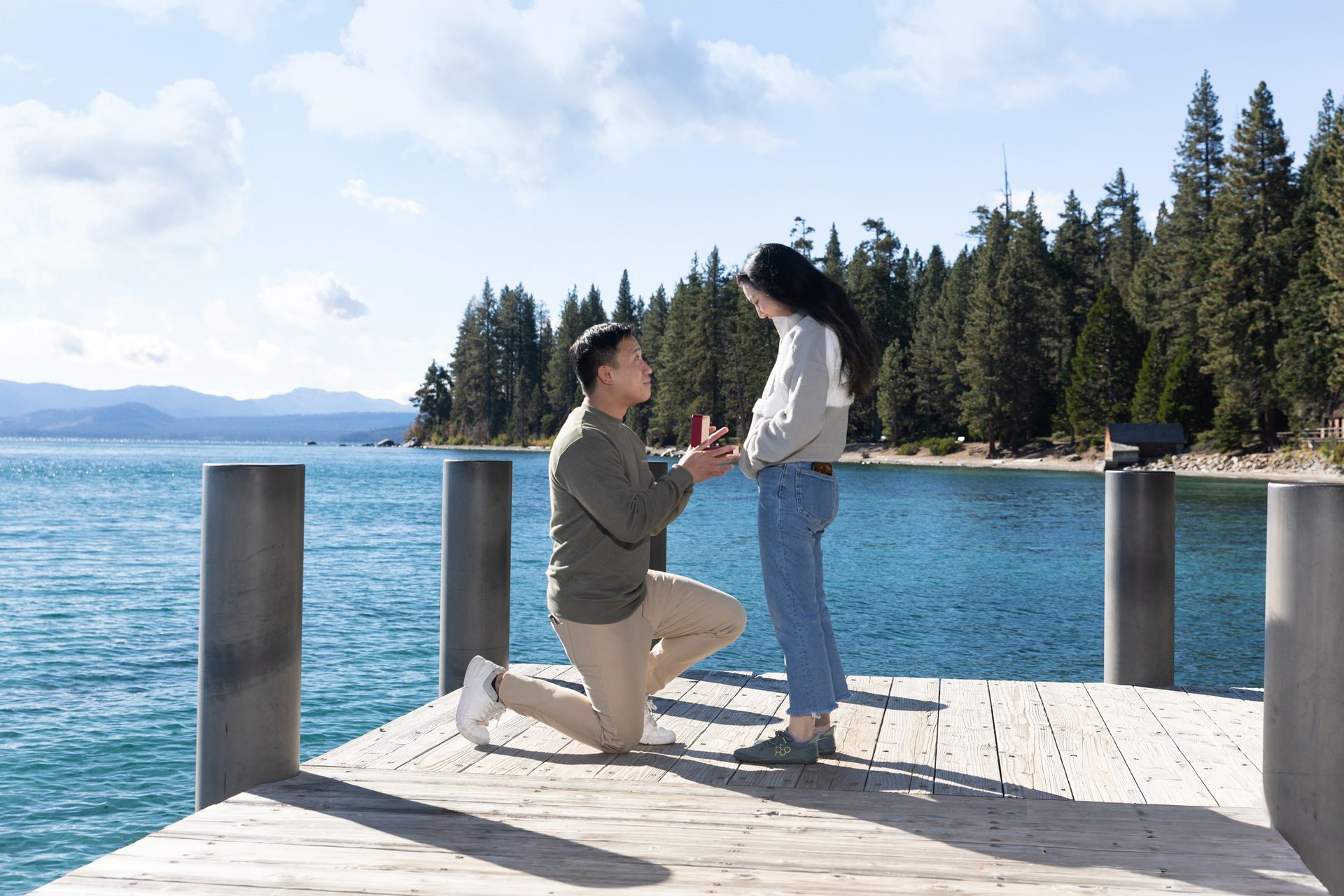 Arthur proposing to Amy on the west shore of Lake Tahoe at sunset, surrounded by golden light and calm water.