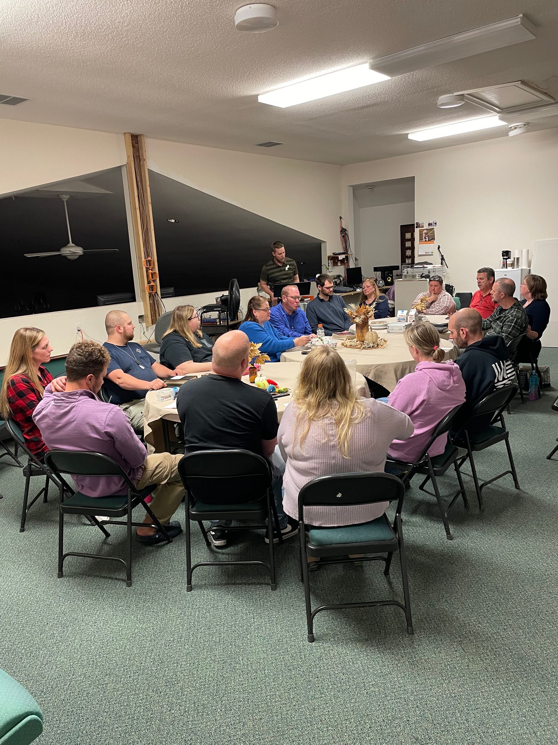 A group of people are sitting around a table in a room.