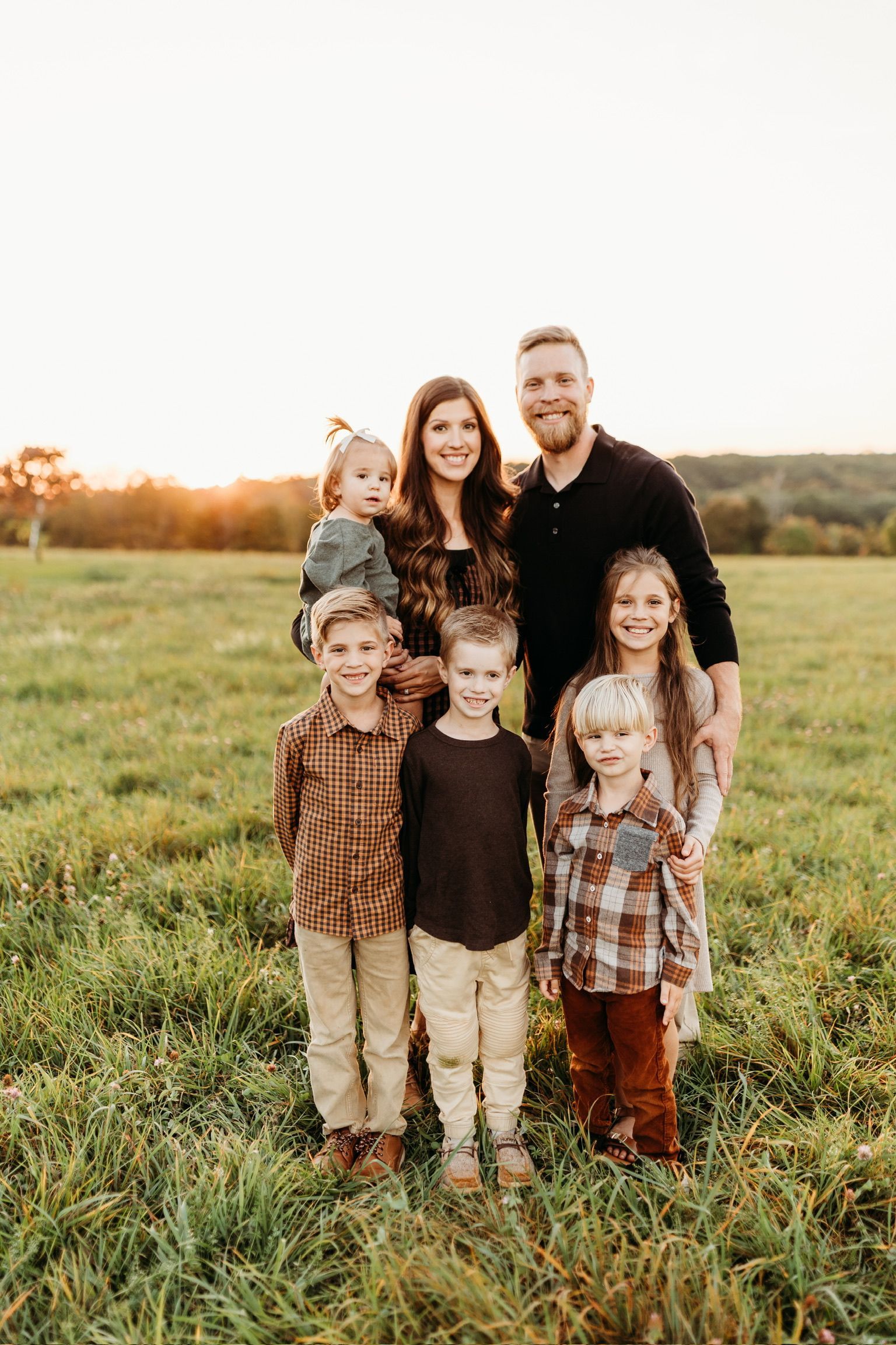 A family is posing for a picture in a field of tall grass.