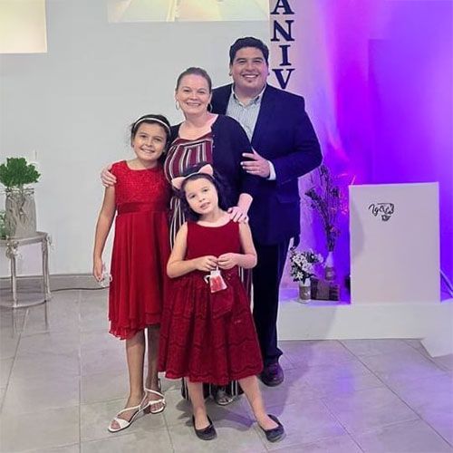 A family is posing for a picture together in a room.