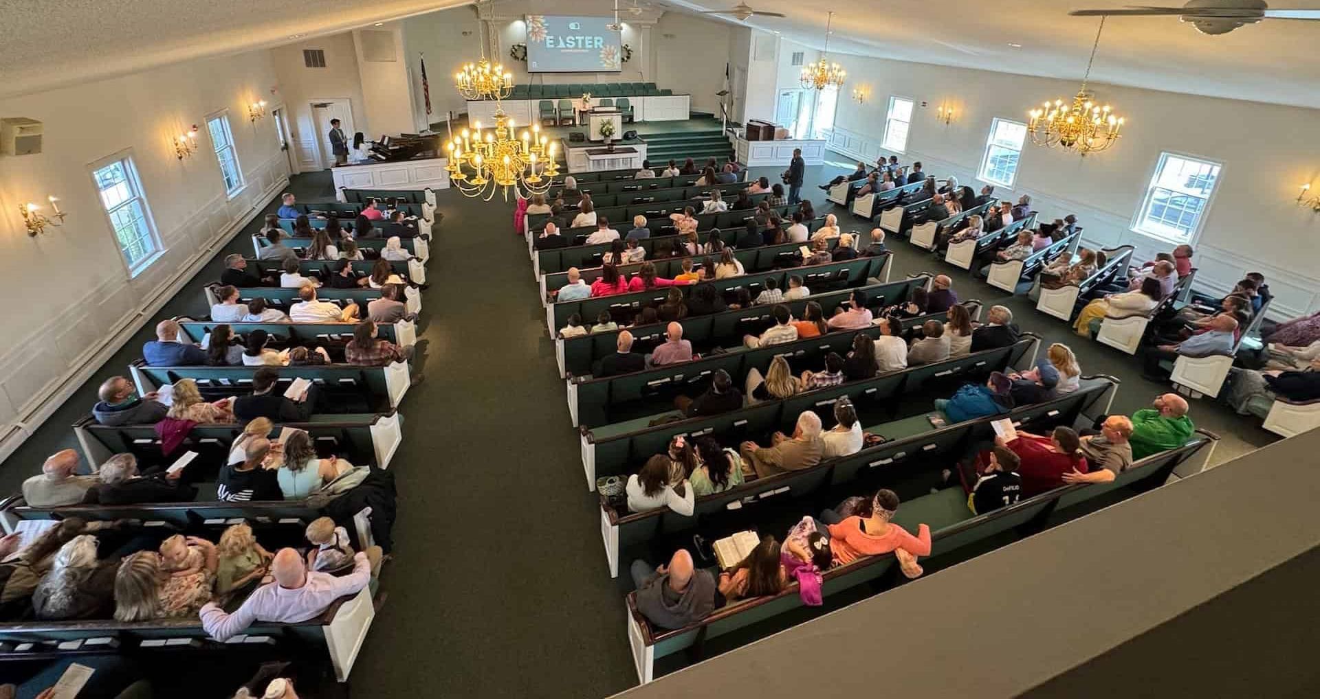 A large group of people are sitting in a church.