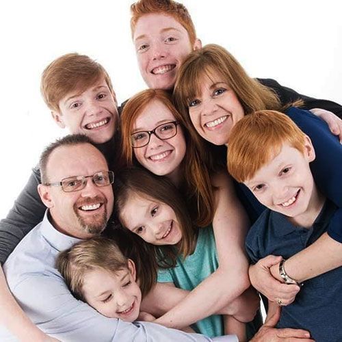 A group of people are hugging each other and smiling.