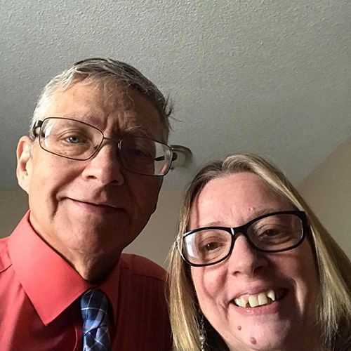 A man and a woman wearing glasses are posing for a picture together.