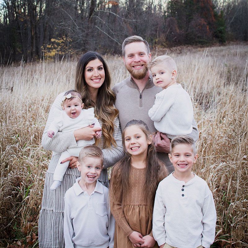 A family is posing for a picture in a field of tall grass.