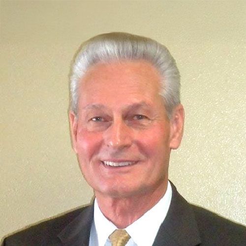 A man in a suit and tie is smiling for the camera.