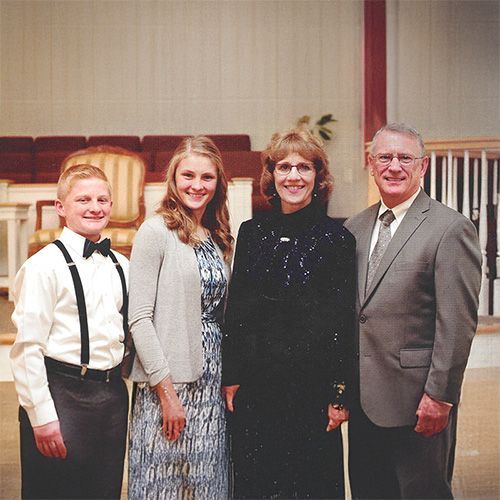A family posing for a picture in front of a church