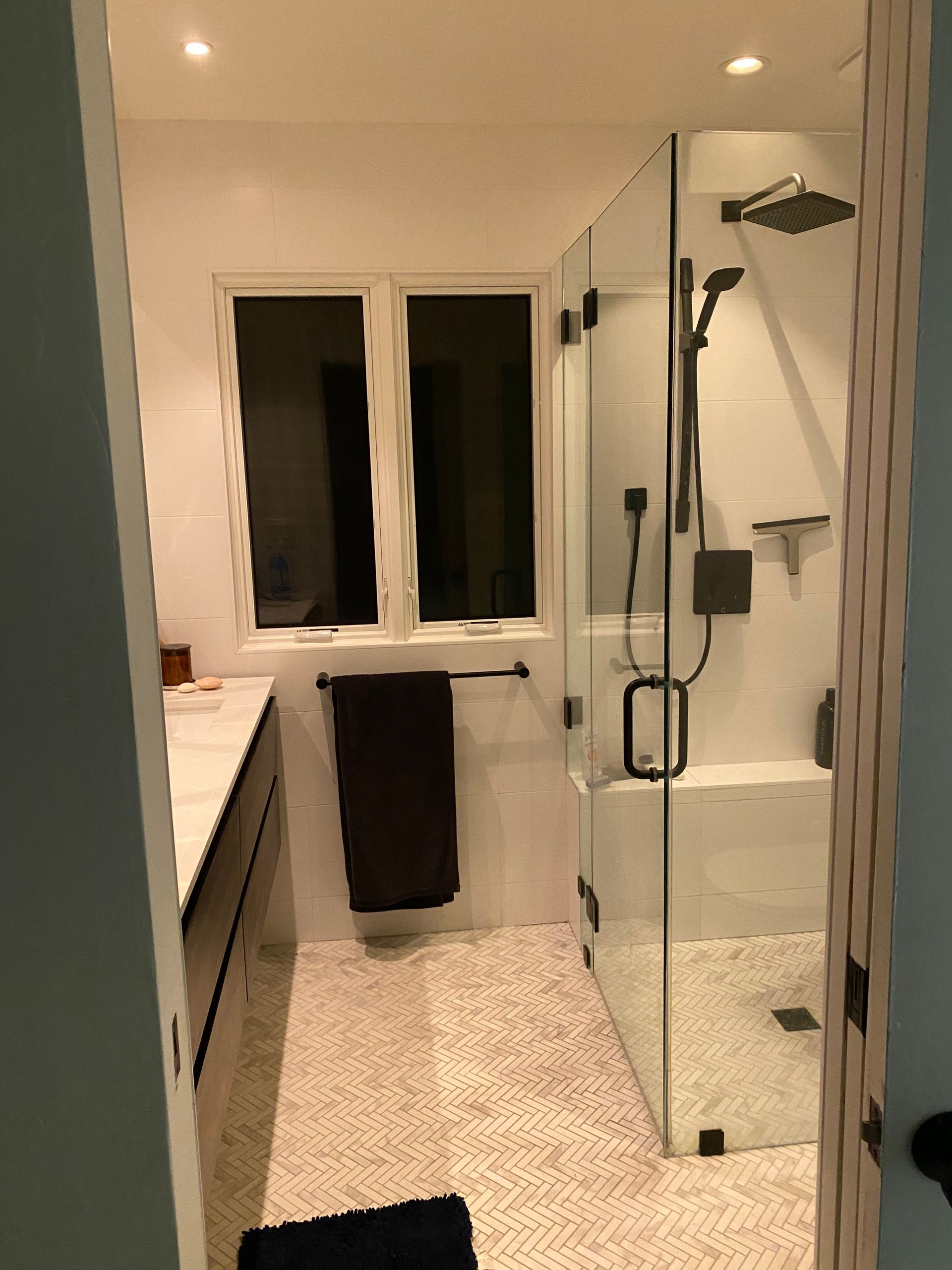 A bathroom with a walk in shower and a window