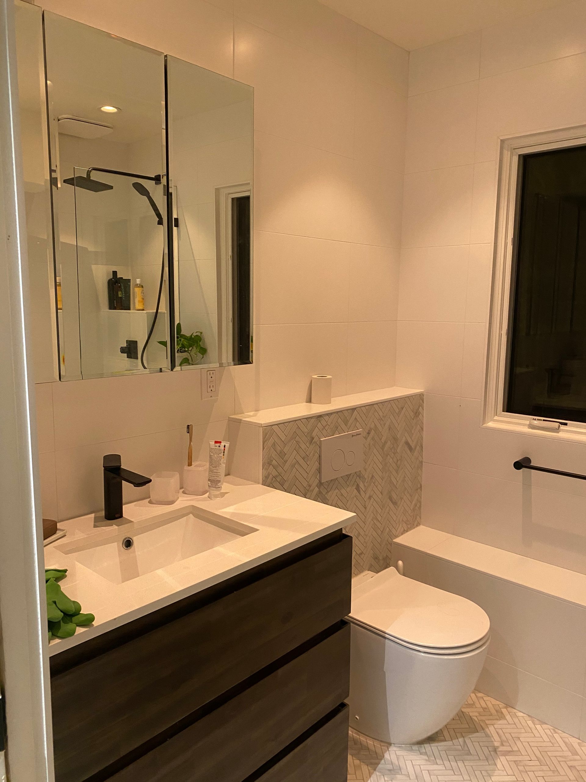 A bathroom with a sink , toilet , tub and mirror.