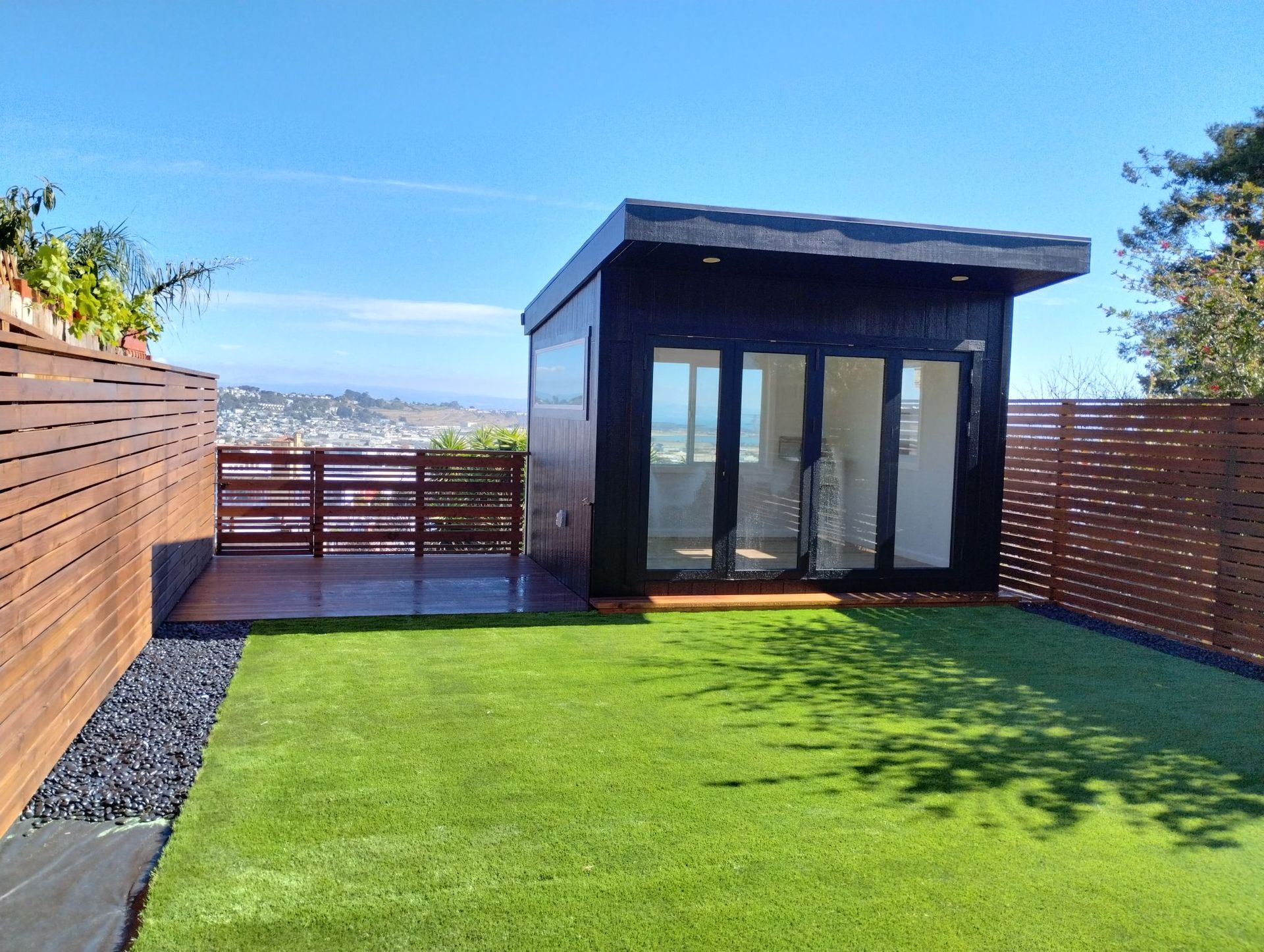 A small house is sitting in the middle of a lush green yard.