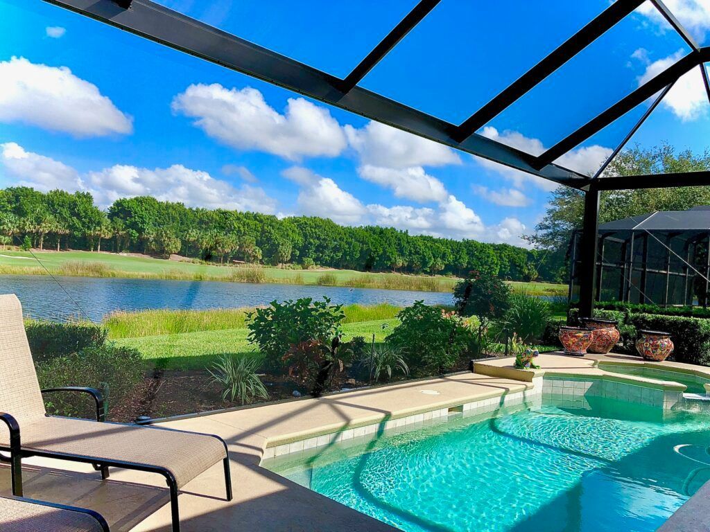 Sunlit screened porch with blue sectional, Home Sweet Home pillow, and woven coffee table.